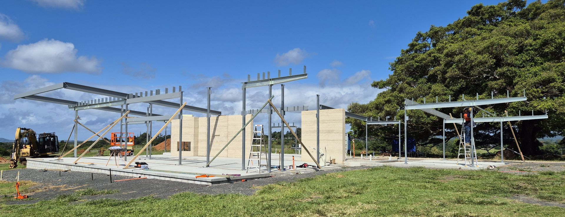 Partially Built Concrete House With Metal Framing Under a Blue Sky on a Grassy Site — Weldcro Fabrication in Ballina, NSW