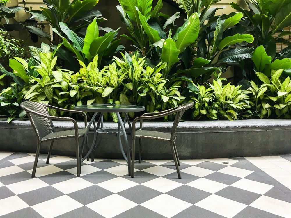 There Is a Patio with Two Chairs, A Table and Plants — Affordable Tiling & Waterproofing in Kirwan, QLD