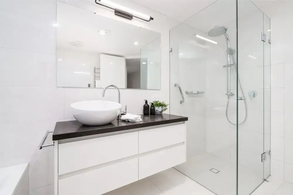 A Bathroom with A Sink, Mirror and Walk in Shower — Affordable Tiling & Waterproofing in Kirwan, QLD