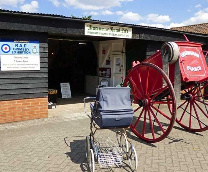 A stroller is parked in front of a building with a sign that says raf on it