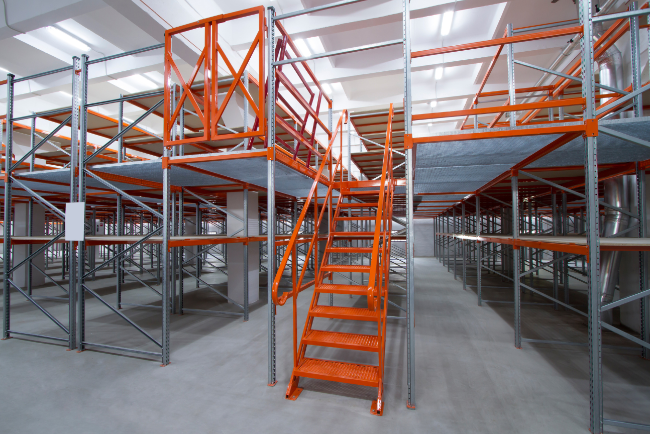 Warehouse interior with orange metal stairs and mezzanine storage racks