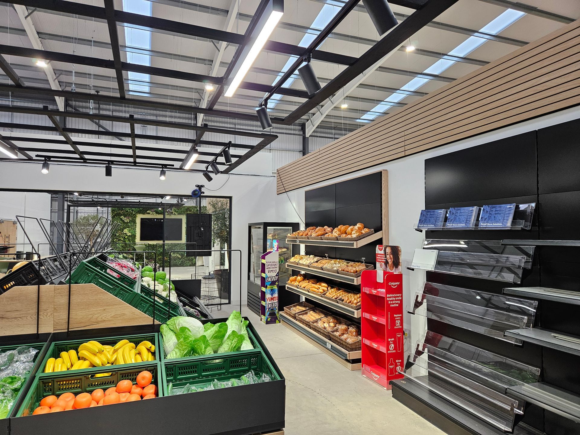Modern grocery store interior with produce displays and shelves under a high ceiling