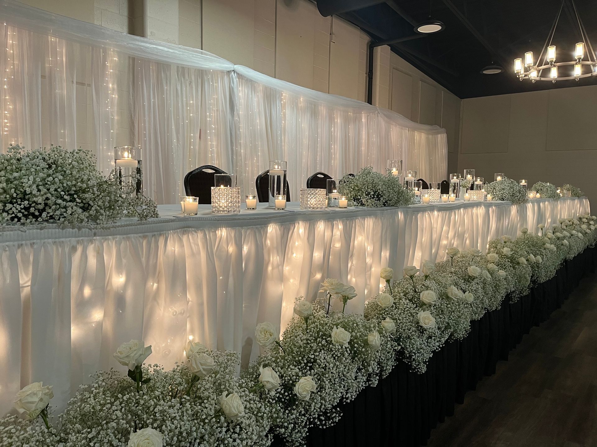 A long table with baby 's breath and candles on it