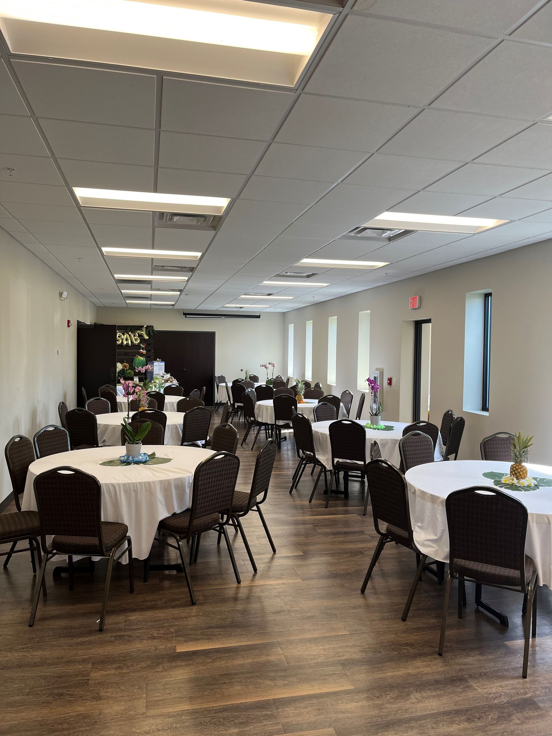 A large room with tables and chairs set up for a party.