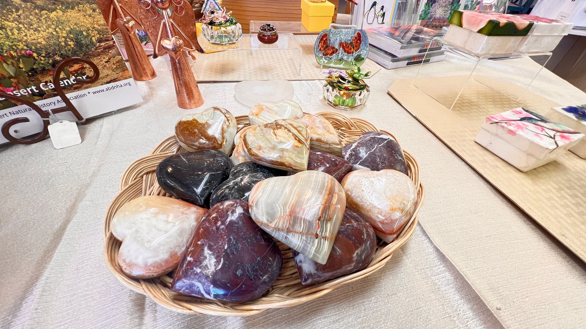 Basket of assorted polished stones and crystals on a table at an outdoor market