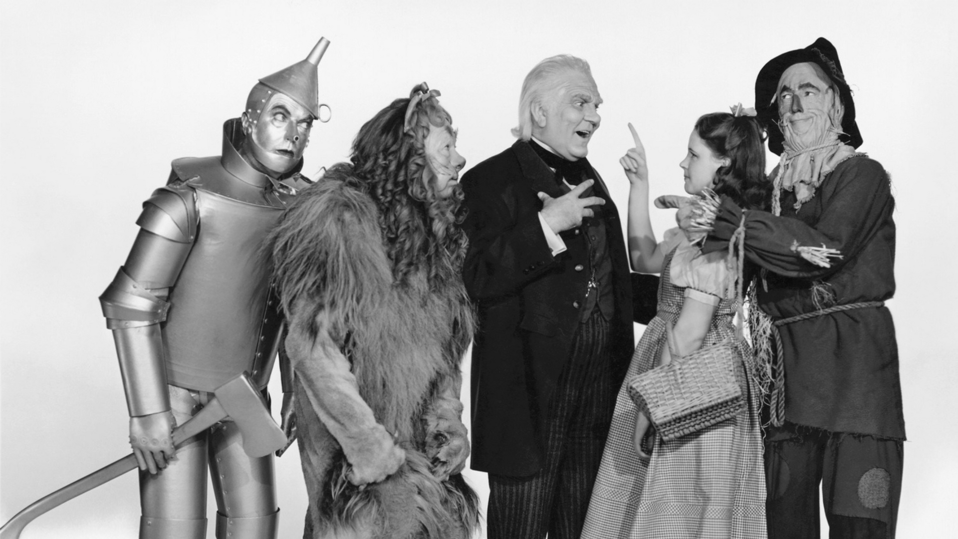Costumed cast of The Wizard of Oz posing together on a studio set