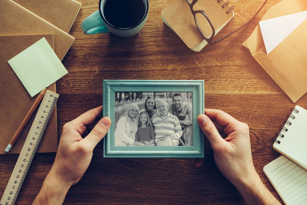 A Person Is Holding a Picture of A Family in A Frame — The Framer In Taree, NSW