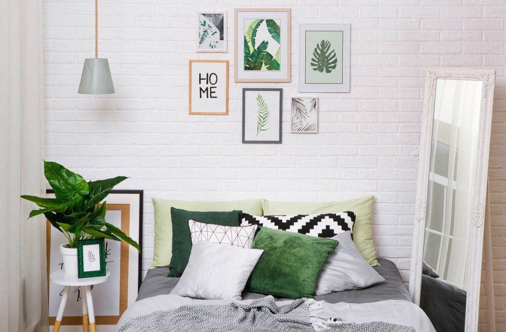 A Bedroom with A Bed, a Plant, a Mirror and A Brick Wall — The Framer In Taree, NSW