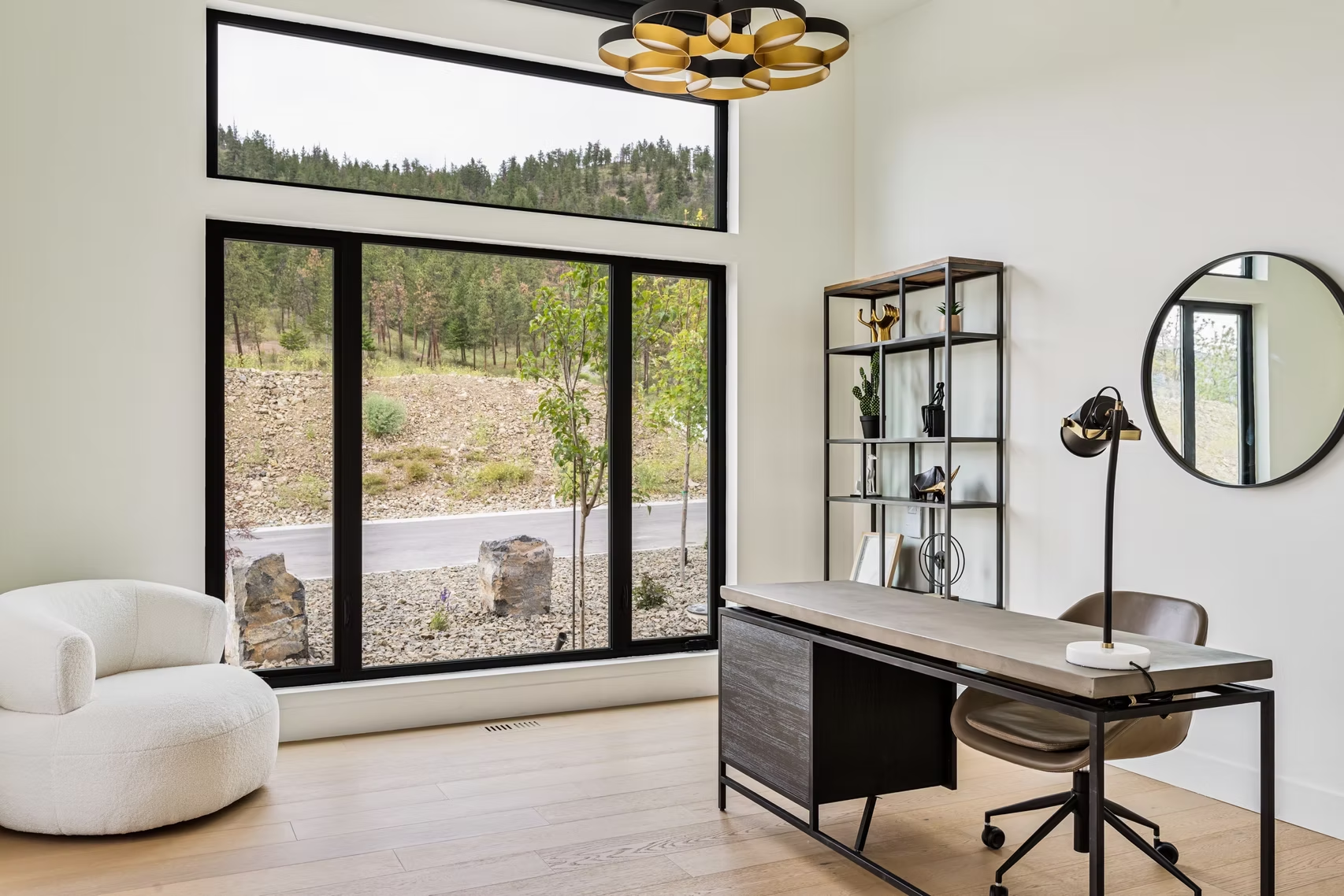 Modern bathroom with freestanding tub, wood vanity, large mirror, and mountain-view windows