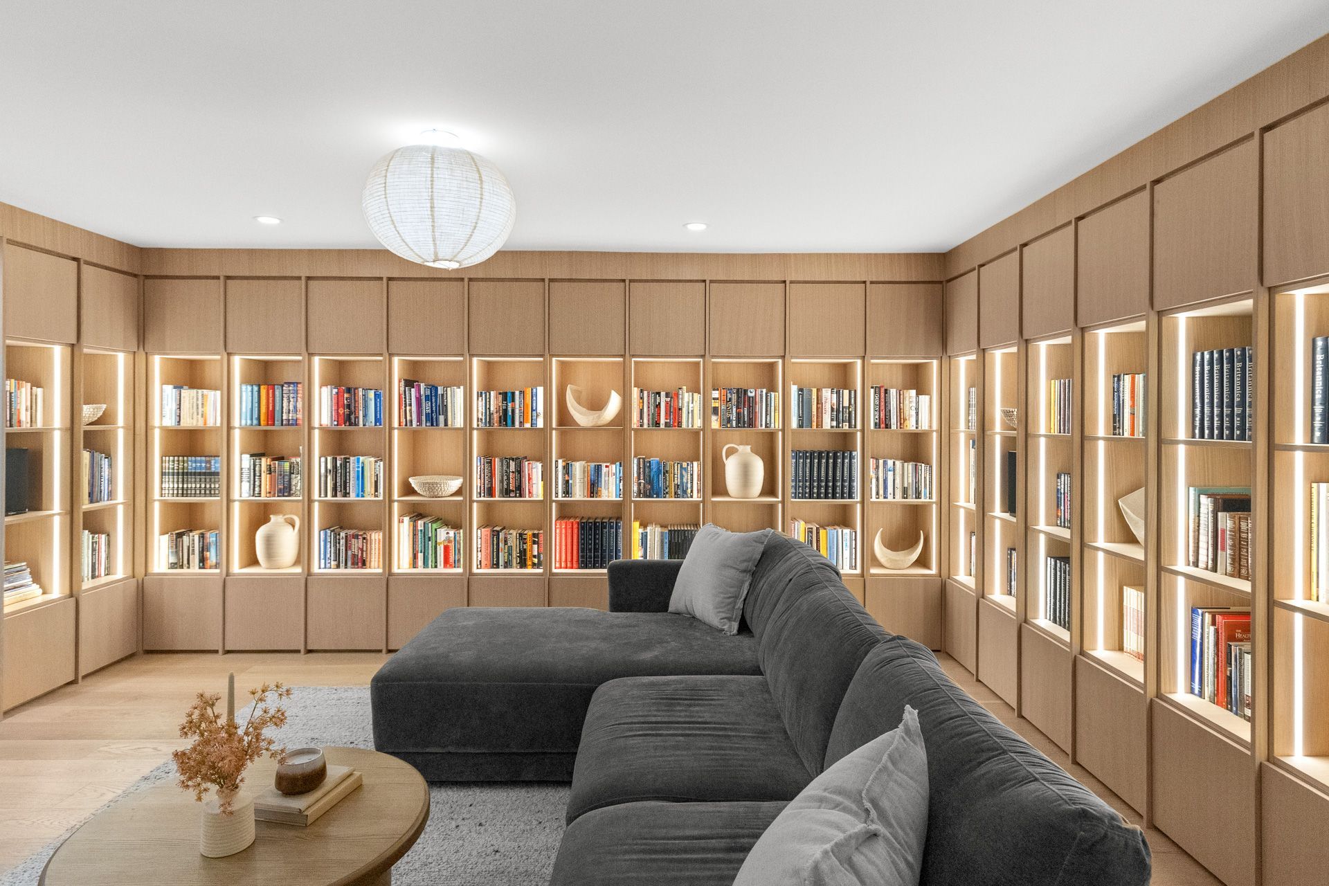 Cozy living room with built-in bookshelves, a gray sectional sofa, and a round coffee table