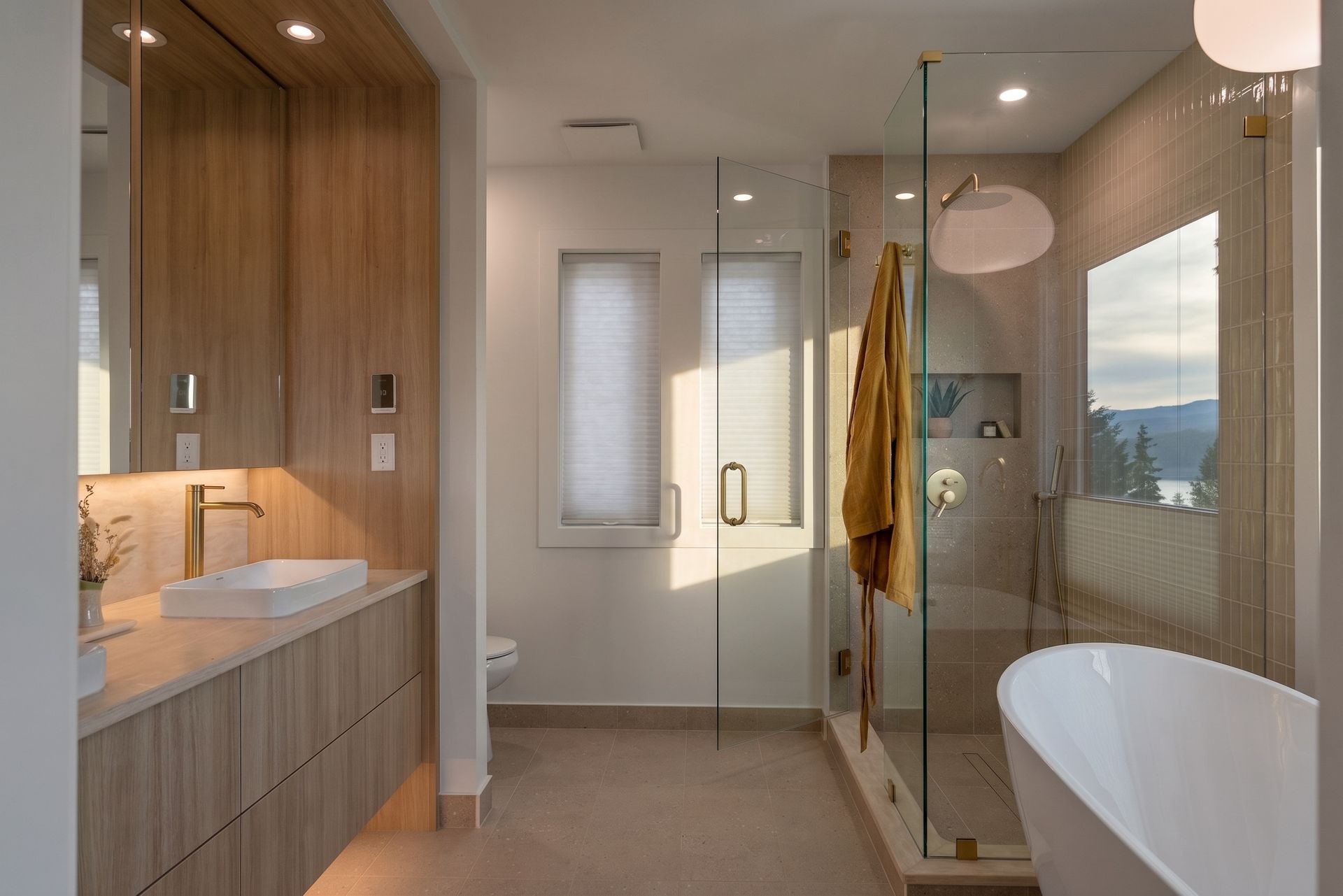 Modern bathroom with wood vanity, glass shower, freestanding tub, and warm neutral finishes