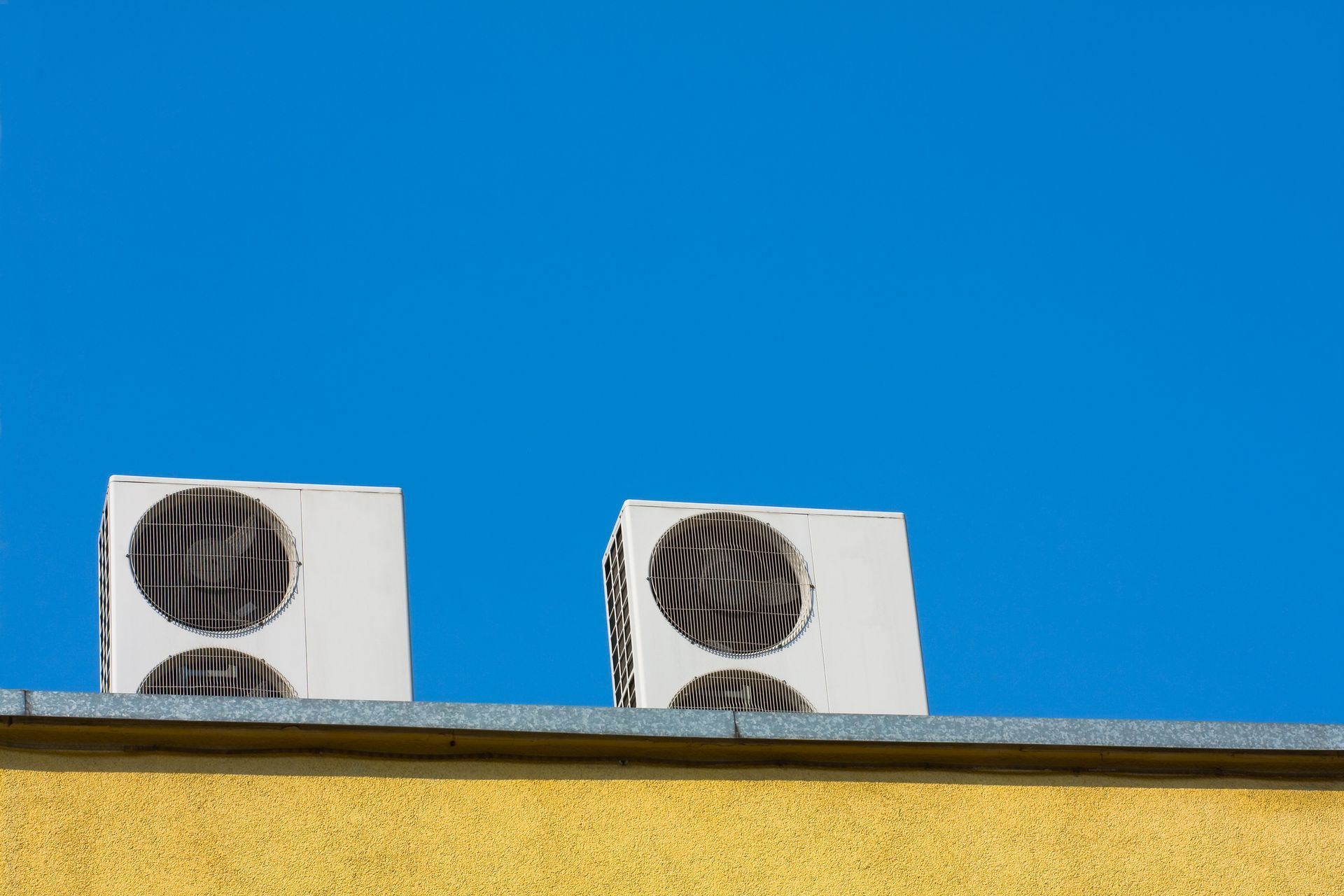 Two air conditioning units on a building, designed by an HVAC System Engineer in Royal Oak, MI.