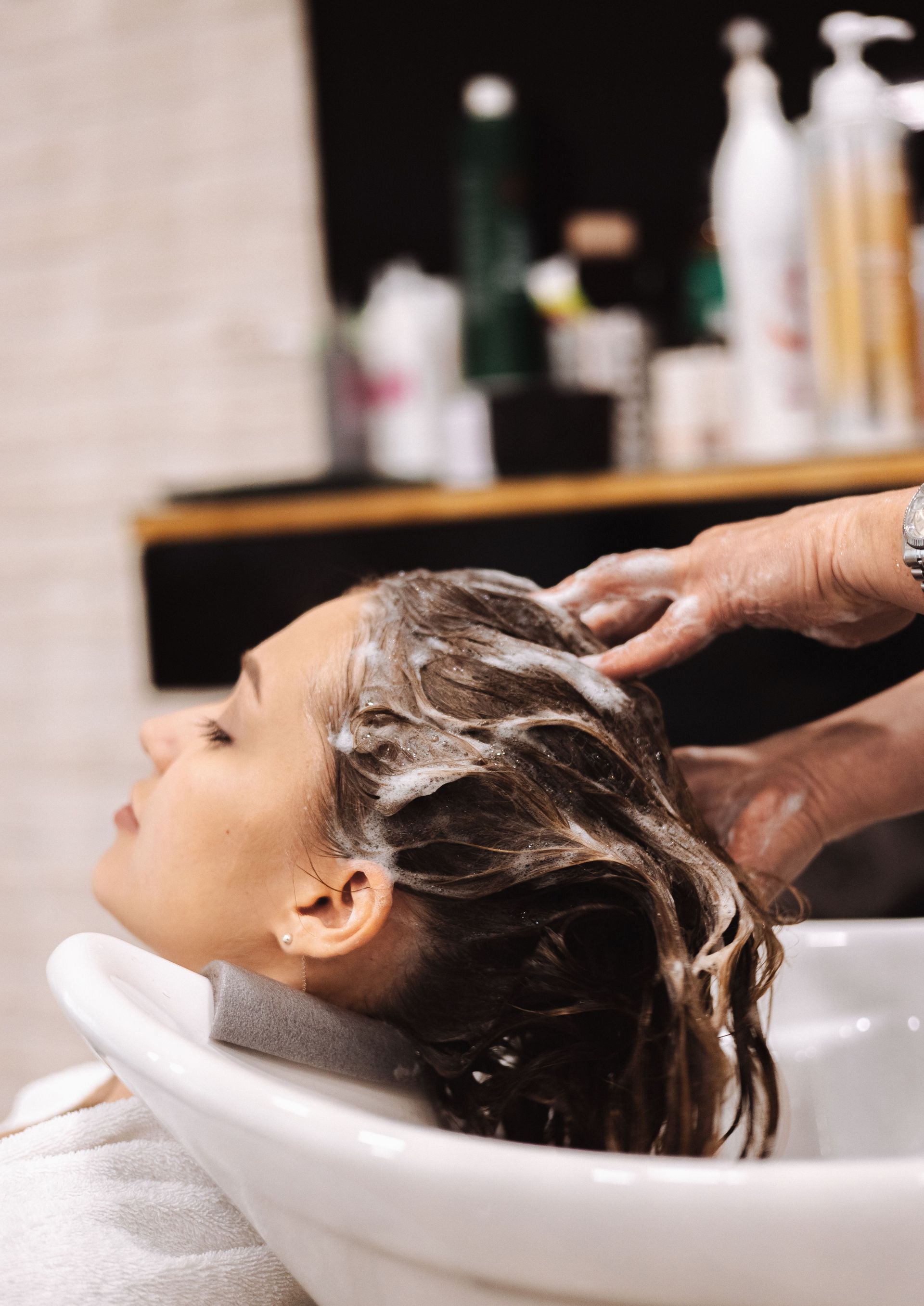 Woman getting her hair washed at a salon shampoo bowl