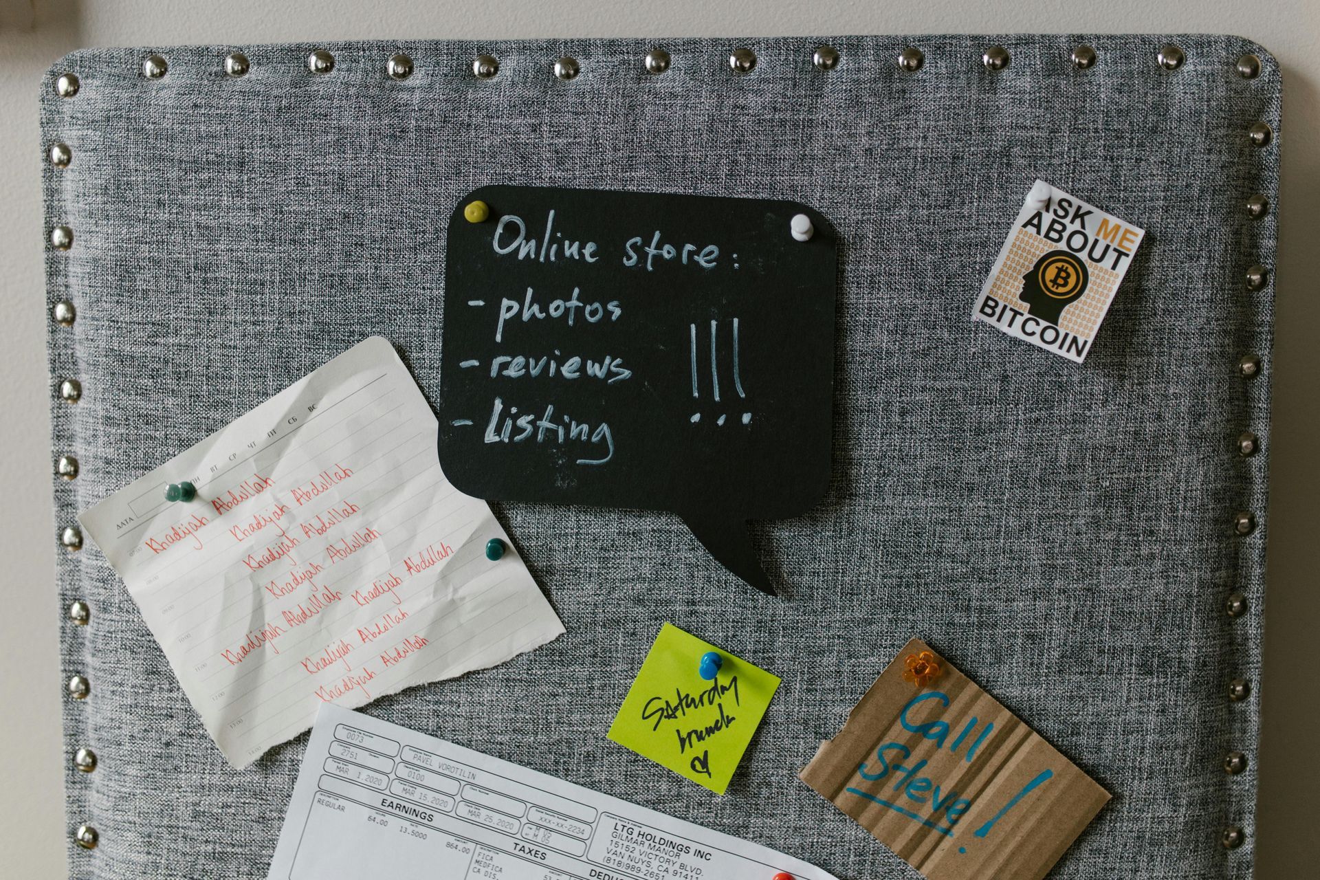 Gray bulletin board with handwritten notes and pins.