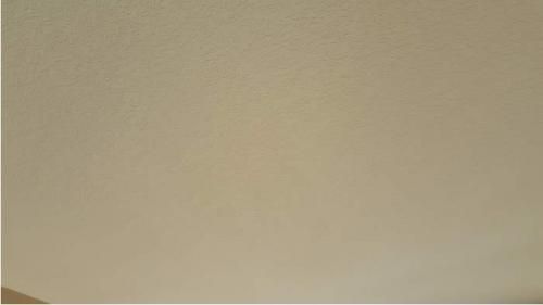 Blank beige wall with a darker baseboard along the bottom edge
