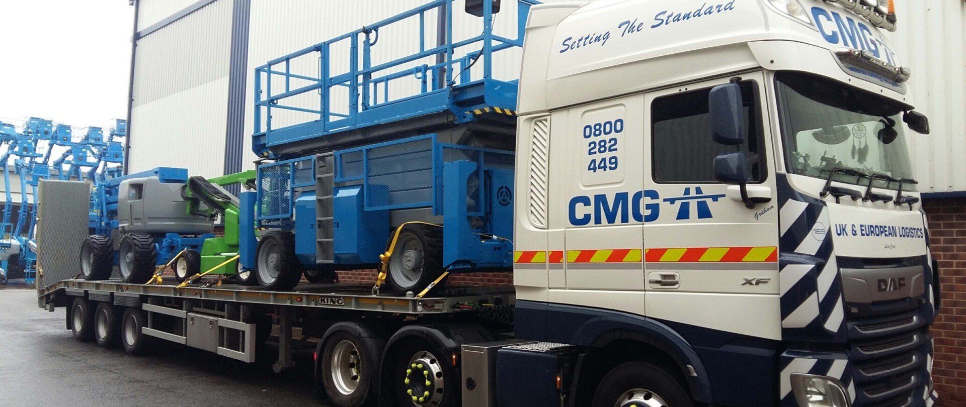 A large blue and white truck with the word cmg on the side.