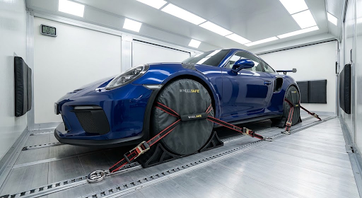 Pristine interior of a climate-controlled vehicle transporter highlighting wheel-protection covers and a secure anchoring system for a sports car
