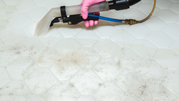 A dirty mattress is being cleaned by a professional cleaner in Hastings. The professional equipment is doing a good job of clearing the debris.
