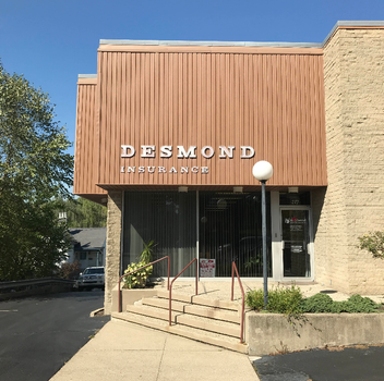 Desmond Insurance office building with brown and tan exterior, steps, and a sign.