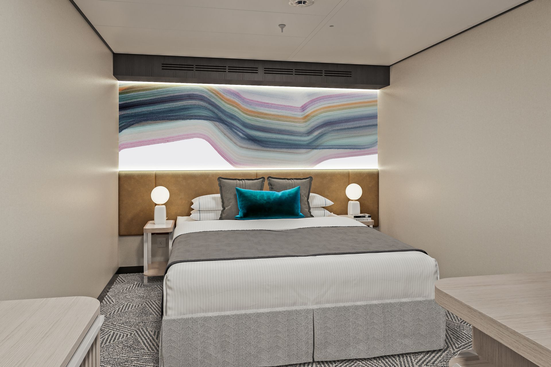 A modern hotel room with a queen bed, grey bedding, teal accent pillow, and abstract wall art above a gold headboard.