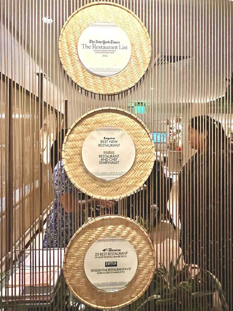 Three gold circular signs on a metallic wall in a softly lit interior lobby