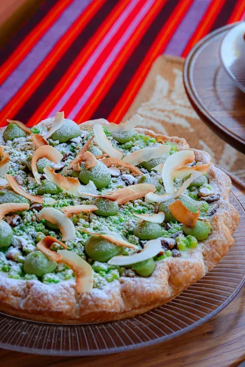 Vegetable pizza on a plate with a striped red tablecloth in the background