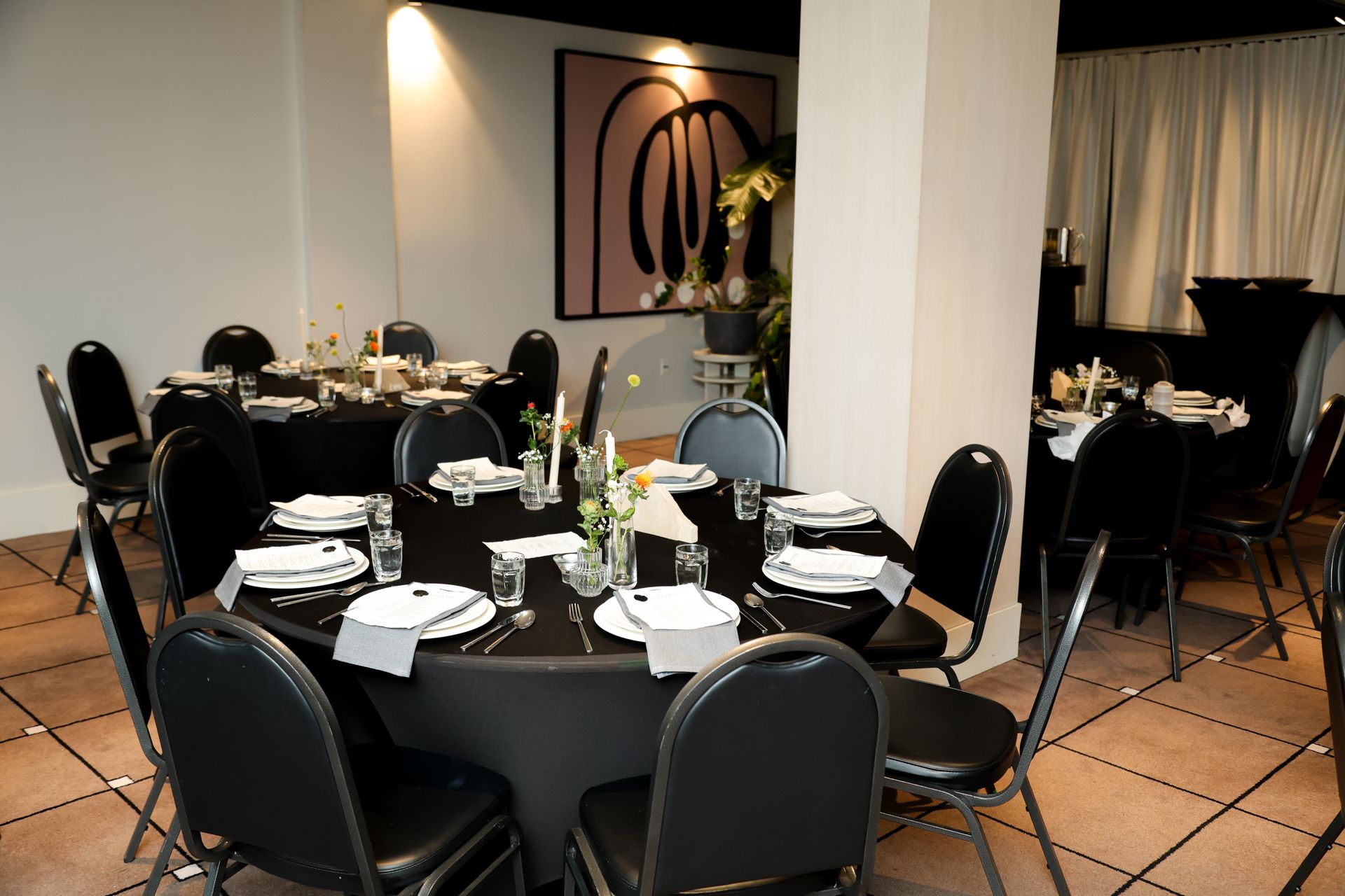 Round banquet tables set for a formal dinner in a warmly lit dining room
