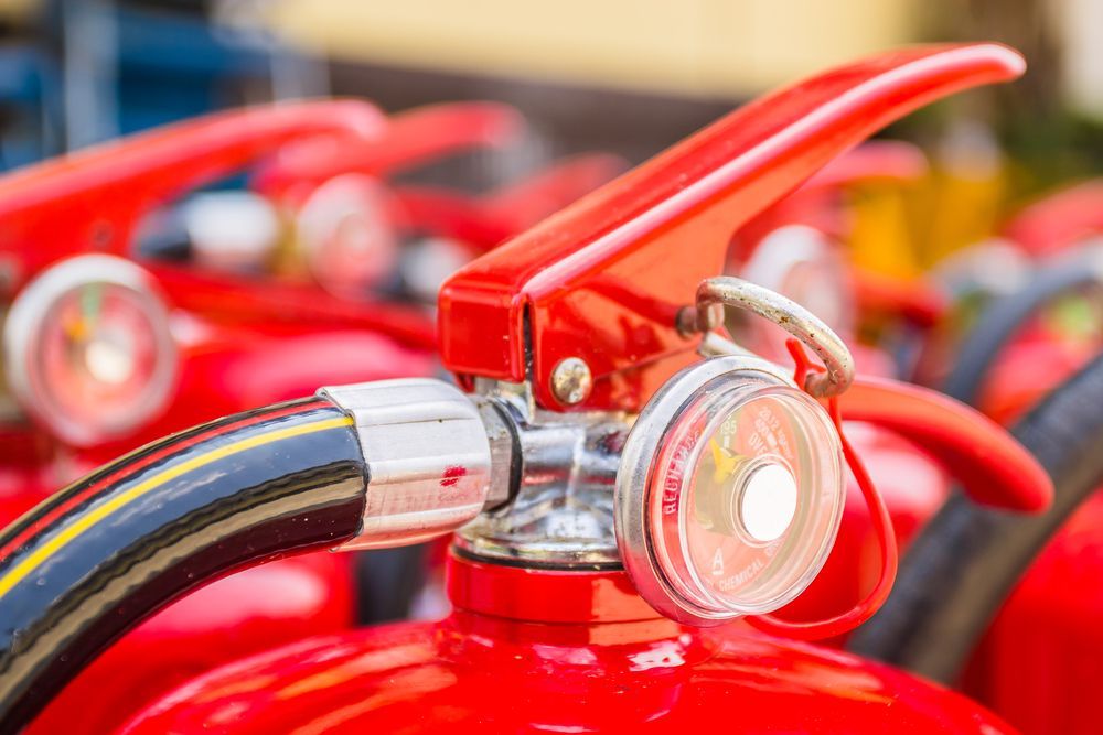 Close-up of Red Fire Extinguisher Handles and Hoses — Safe Industries Group in Forster, NSW