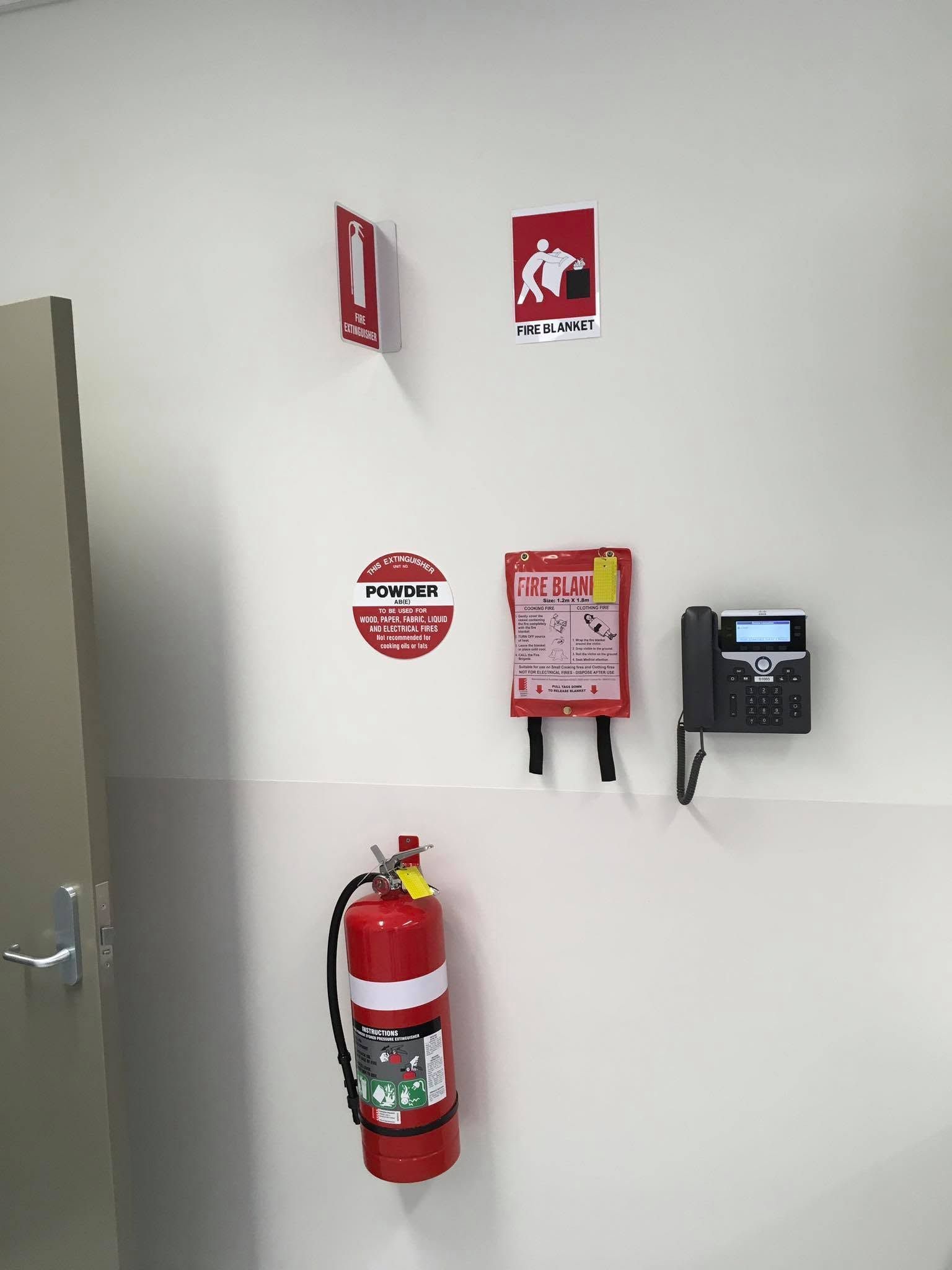 Worker Inspecting a Red Fire Control Panel — Safe Industries Group in Woodrising, NSW
