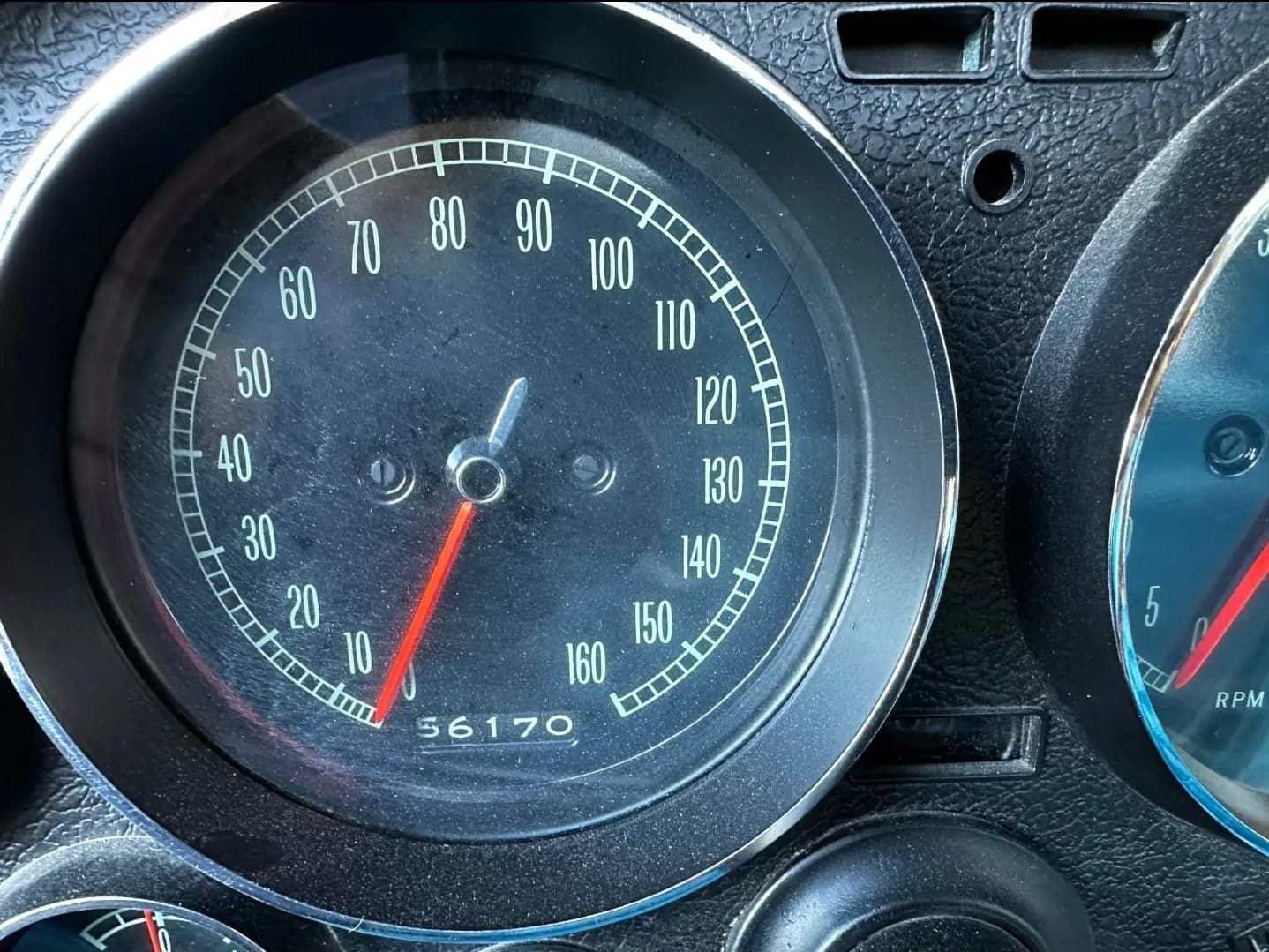 תקריב של מד מהירות של מכונית המציג כ-17,000 מייל, עם מחט אדומה על מד שחור.