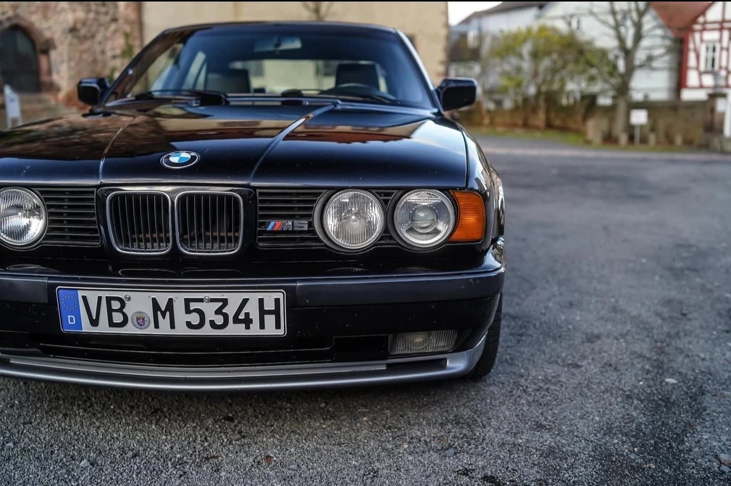 מבט קדמי על מכונית ספורט שחורה מסוג BMW שחונה ברחוב, כאשר פנסים קדמיים ולוחית רישוי נראים לעין