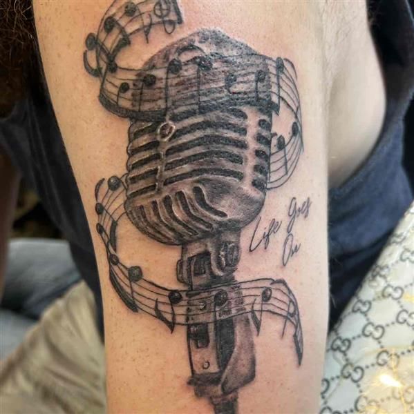 A tattoo artist creates delicate fine line ink on a client in a clean studio setting.