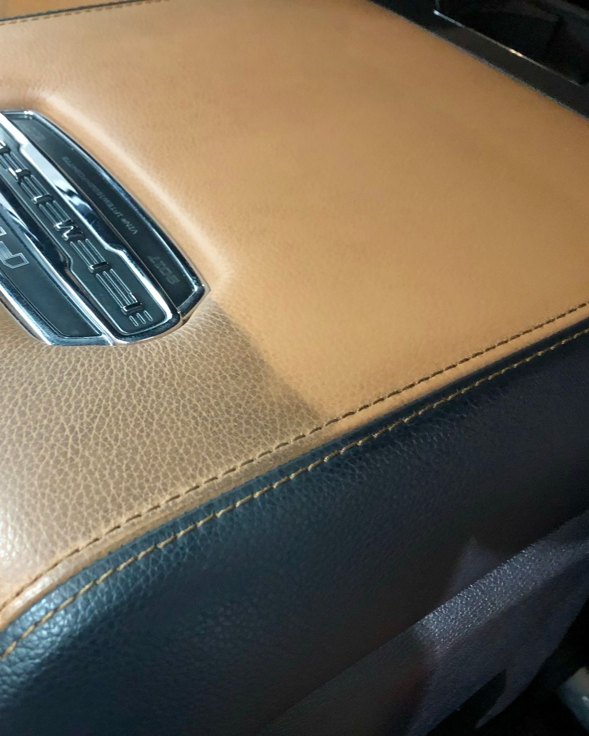 The carpeted driver’s side floor of a vehicle, showing the brake pedal, gas pedal, and floor mat anchor posts.