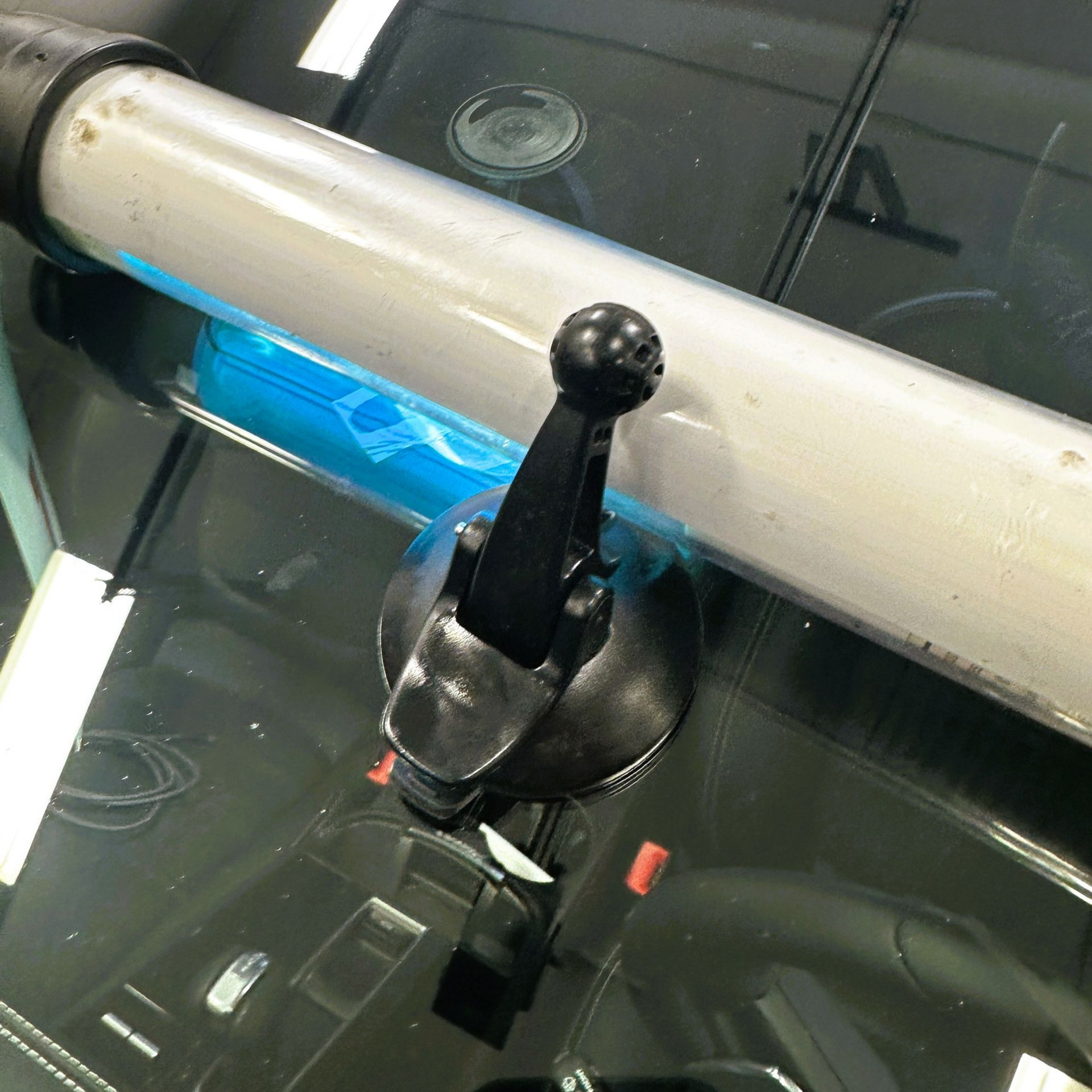 Car’s black gear shifter beside a blue seat under a dashboard view