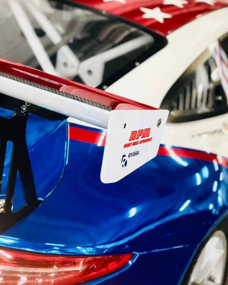 Blue race car with red and white accents, rear wing, and star-patterned roof detail