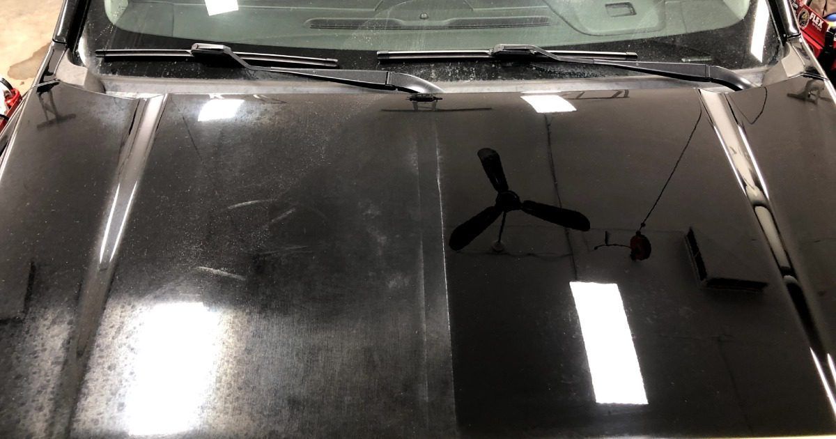 A car hood split into two halves: the left is dull and scratched, while the right is polished, shiny, and reflects light.