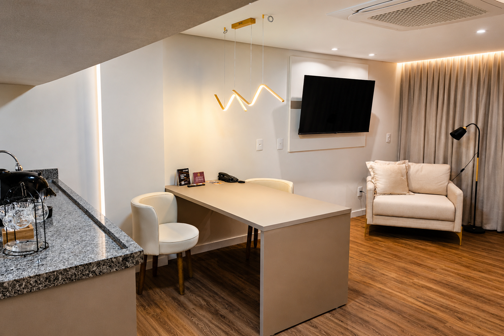 Sala de estar moderna com sofá, escrivaninha, TV de parede e piso de madeira.