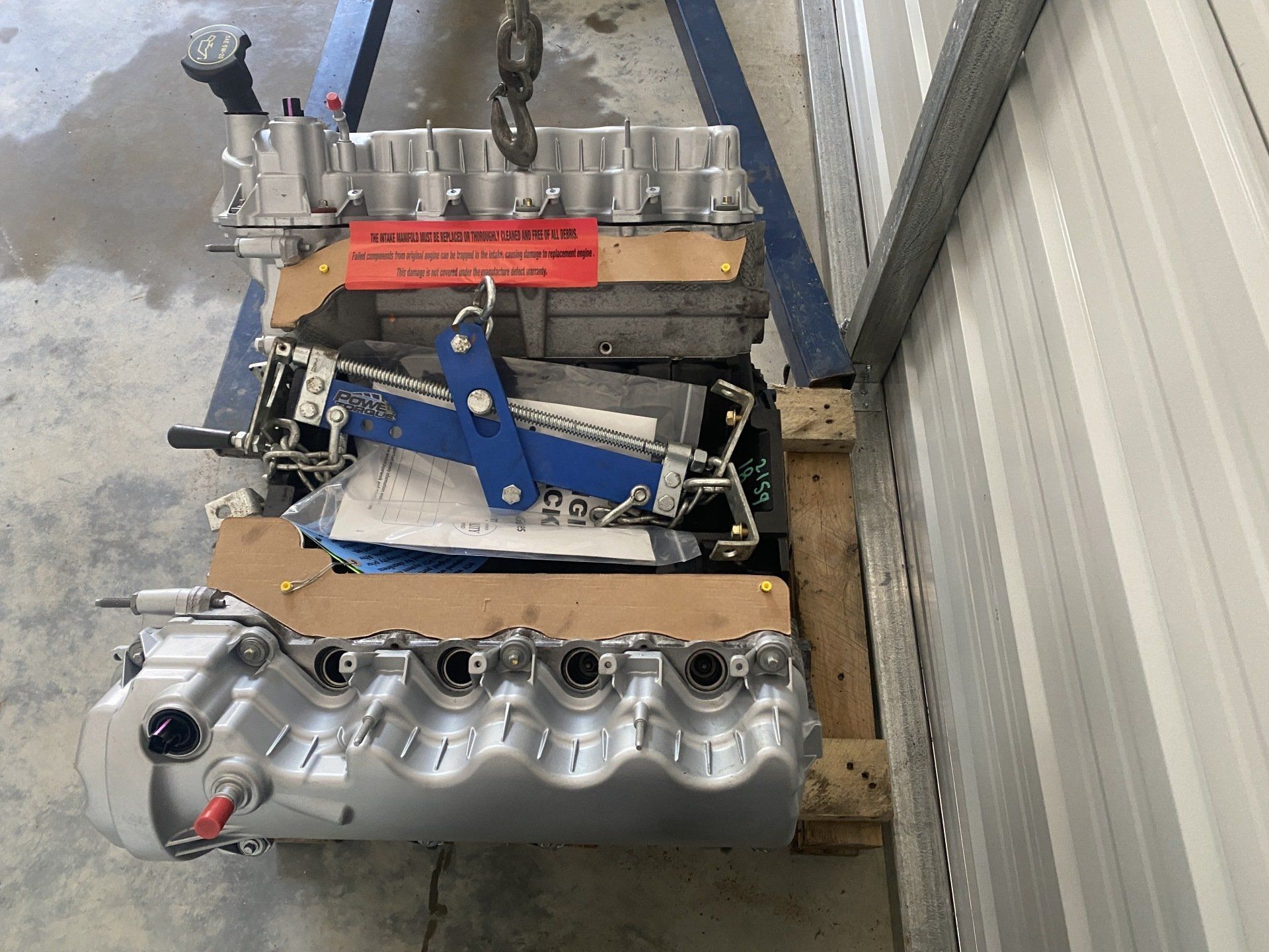 A stainless steel engine is sitting on a wooden pallet