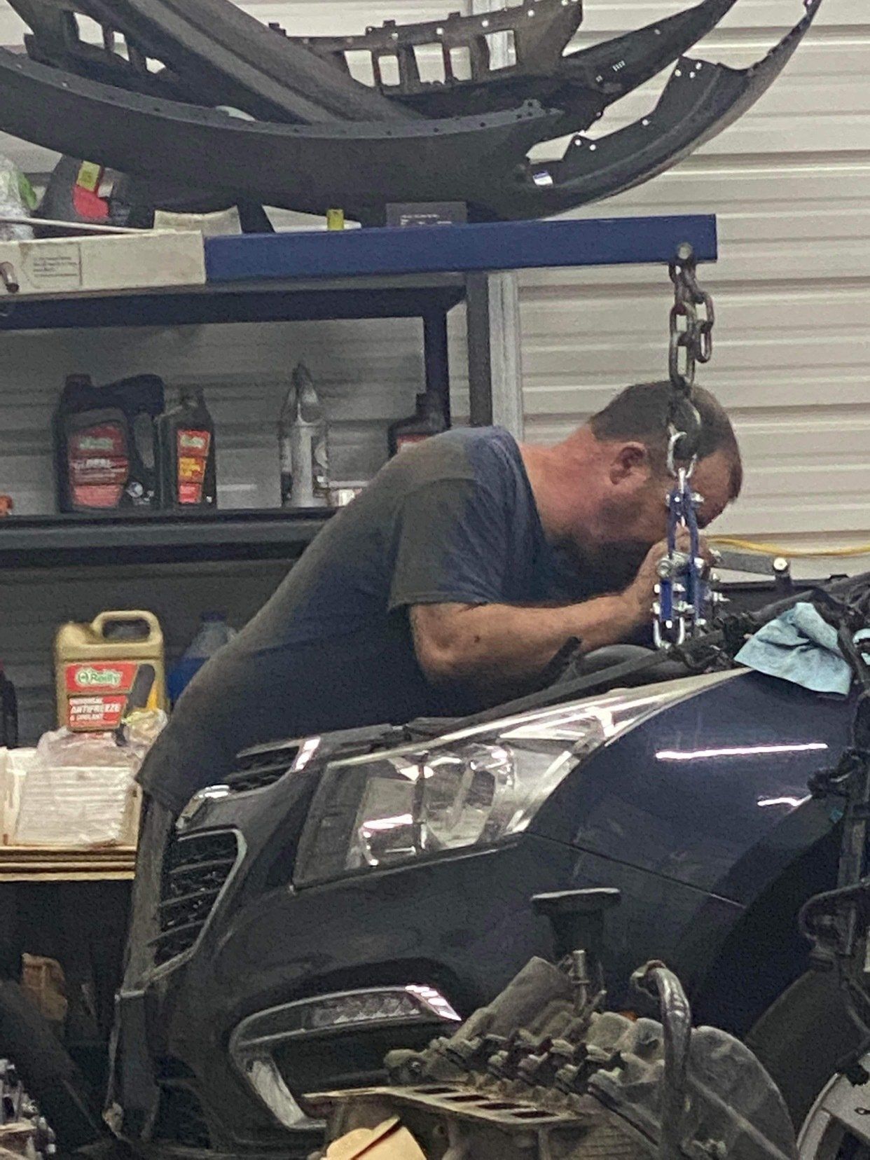 A man is working on a car in a garage.