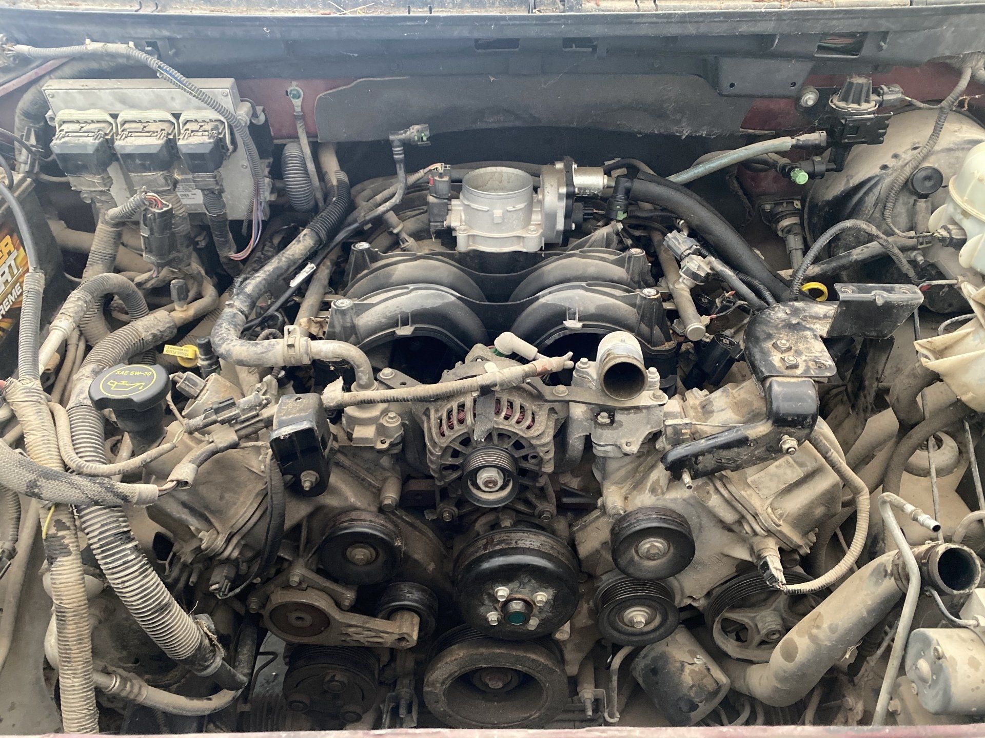 A close up of the engine of a car with the hood open.