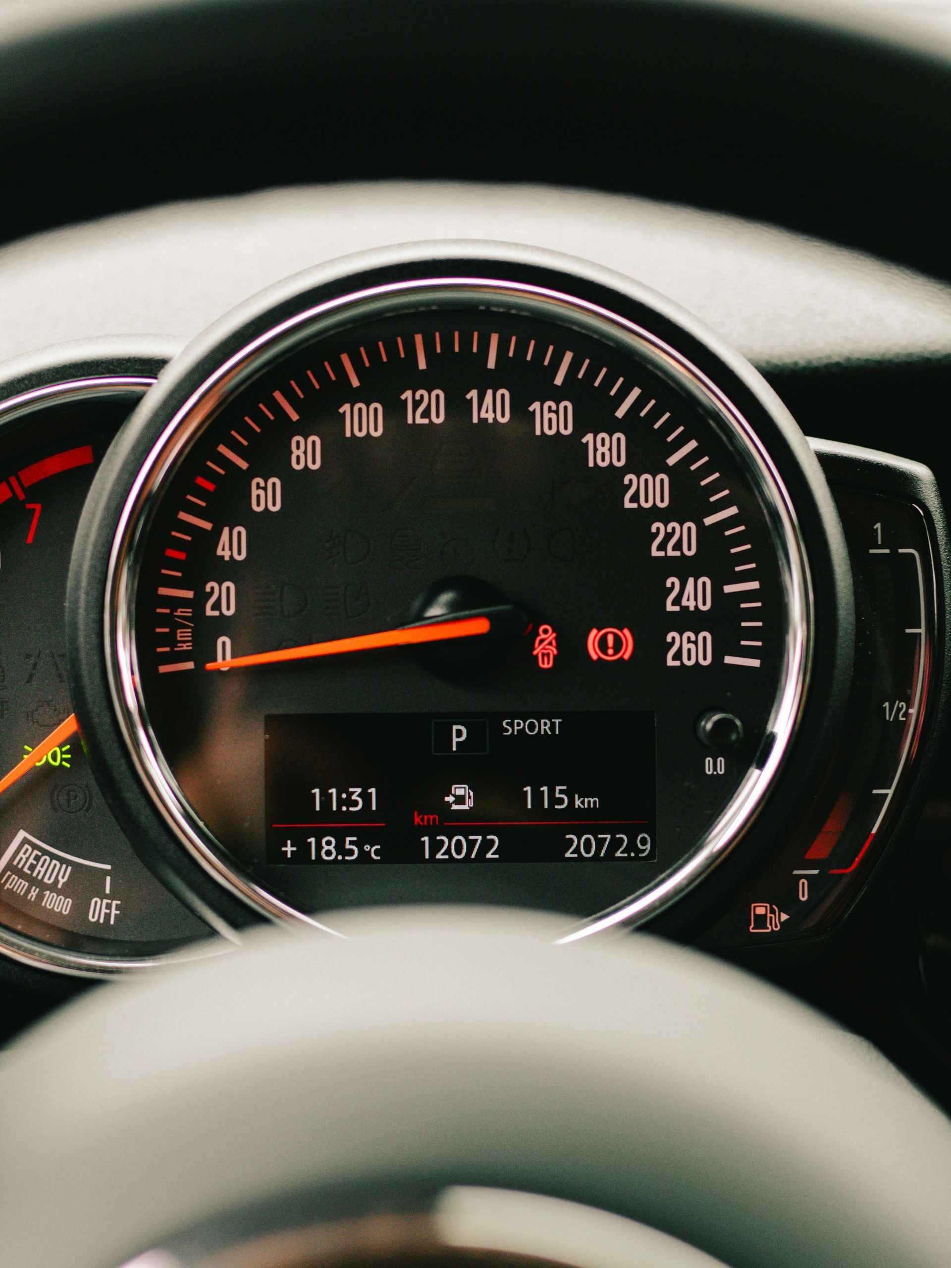 Car dashboard displaying speed at 115 km/h, time 11:31, and other driving information.