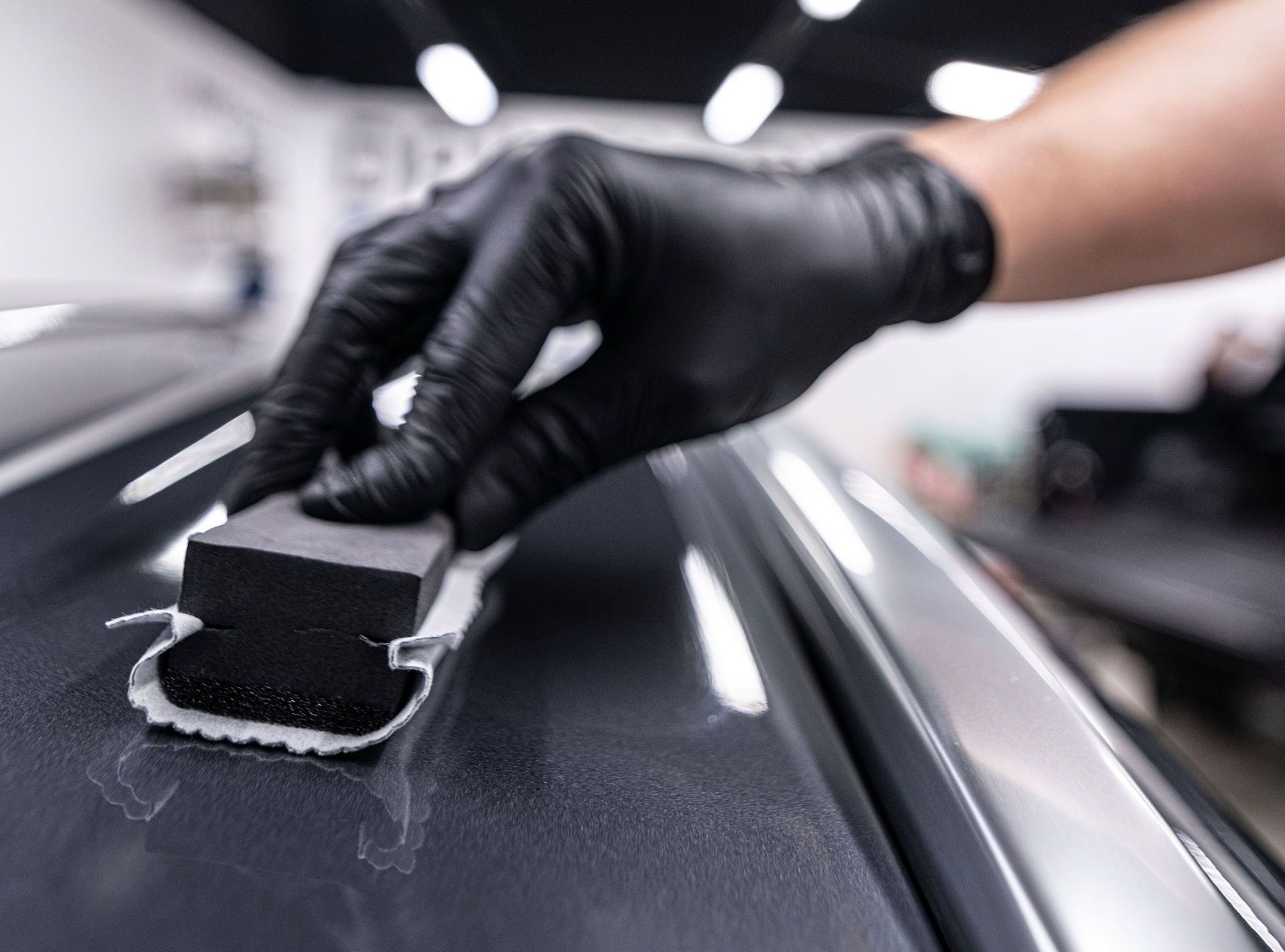 A black mercedes benz s63 amg is parked in a showroom.