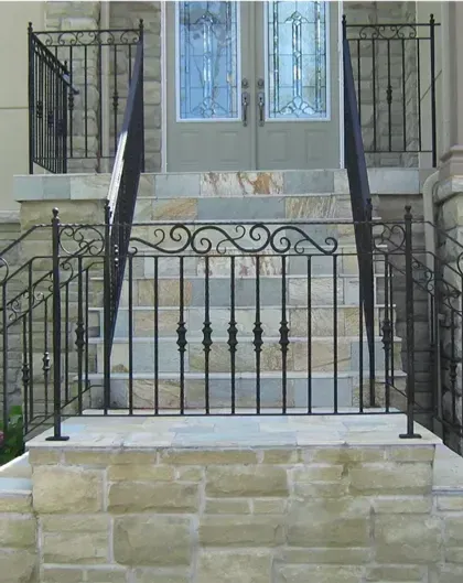 Front steps with black wrought-iron railings leading to a gray double door.