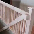 White stair railing with a support brace attached near the top of the banister