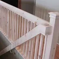 White stair railing with a support brace attached near the top of the banister