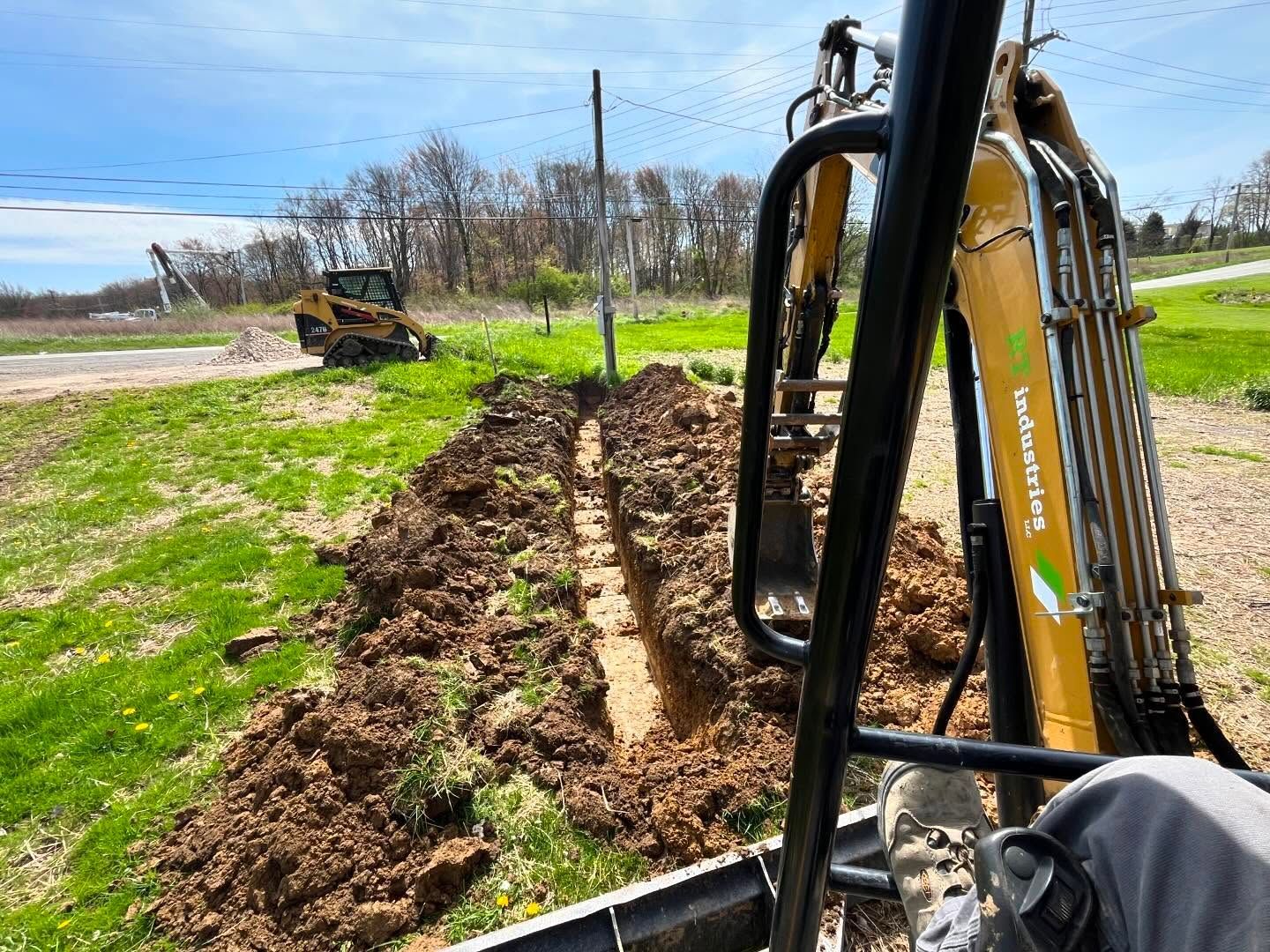 A bulldozer is digging a trench in a field.