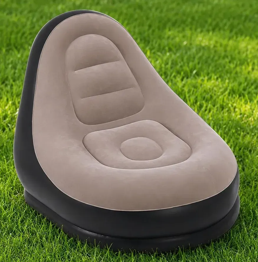 Beige inflatable lounge chair on green grass, with a black base.