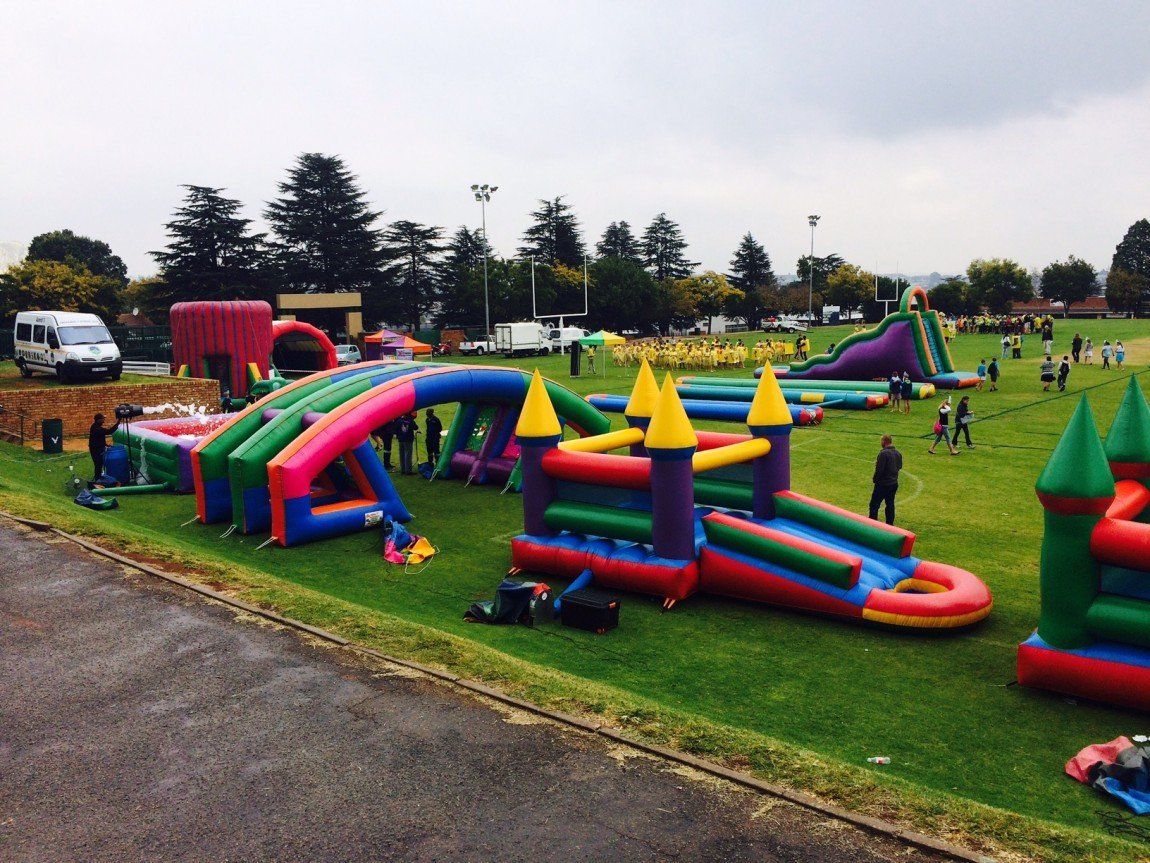 Wide-angle school and corporate fun day with inflatables on sunny field