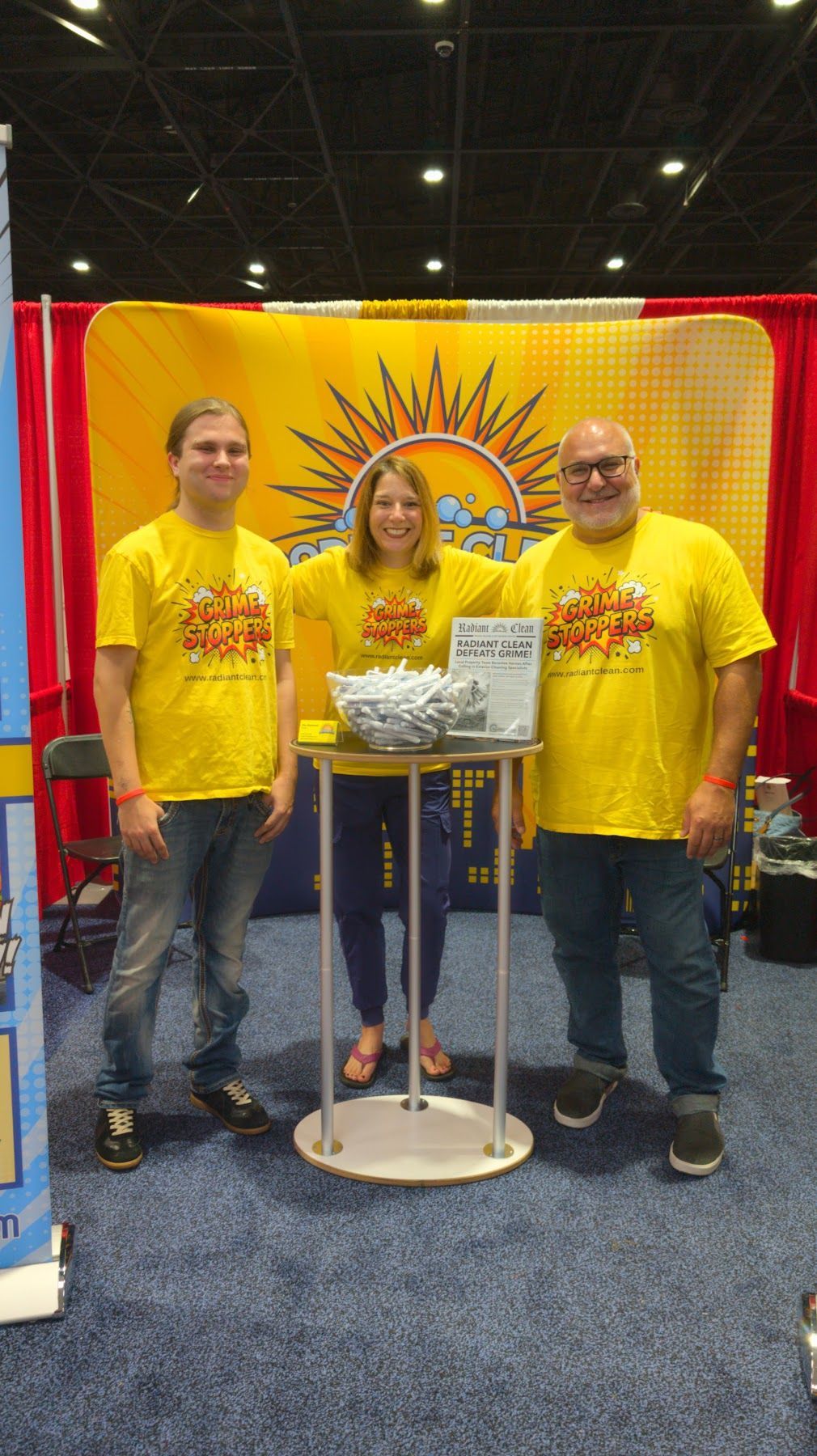 Radiant Clean at a trade show booth with a sunburst banner and display table.