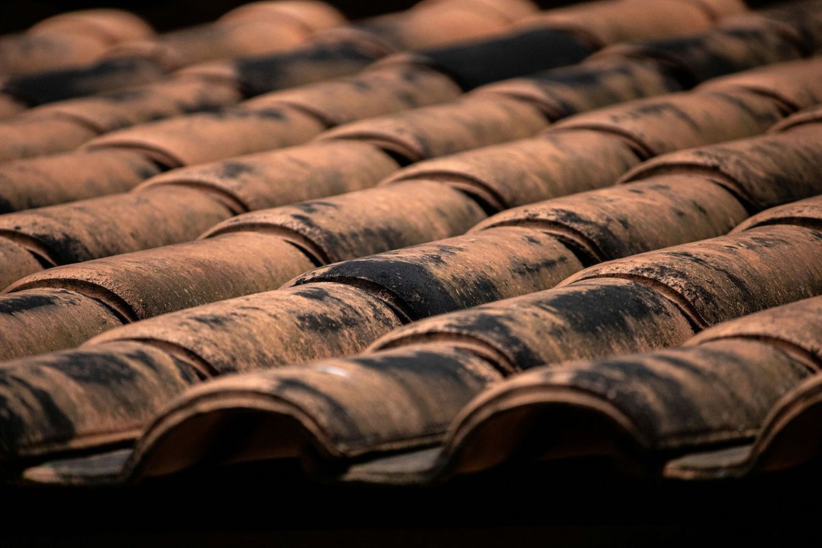 A close up of a row of brown tiles on a roof